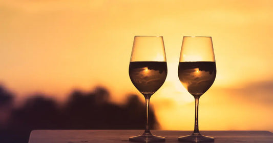 God vin. Her ses to glas af de gode vin i solnedgangen